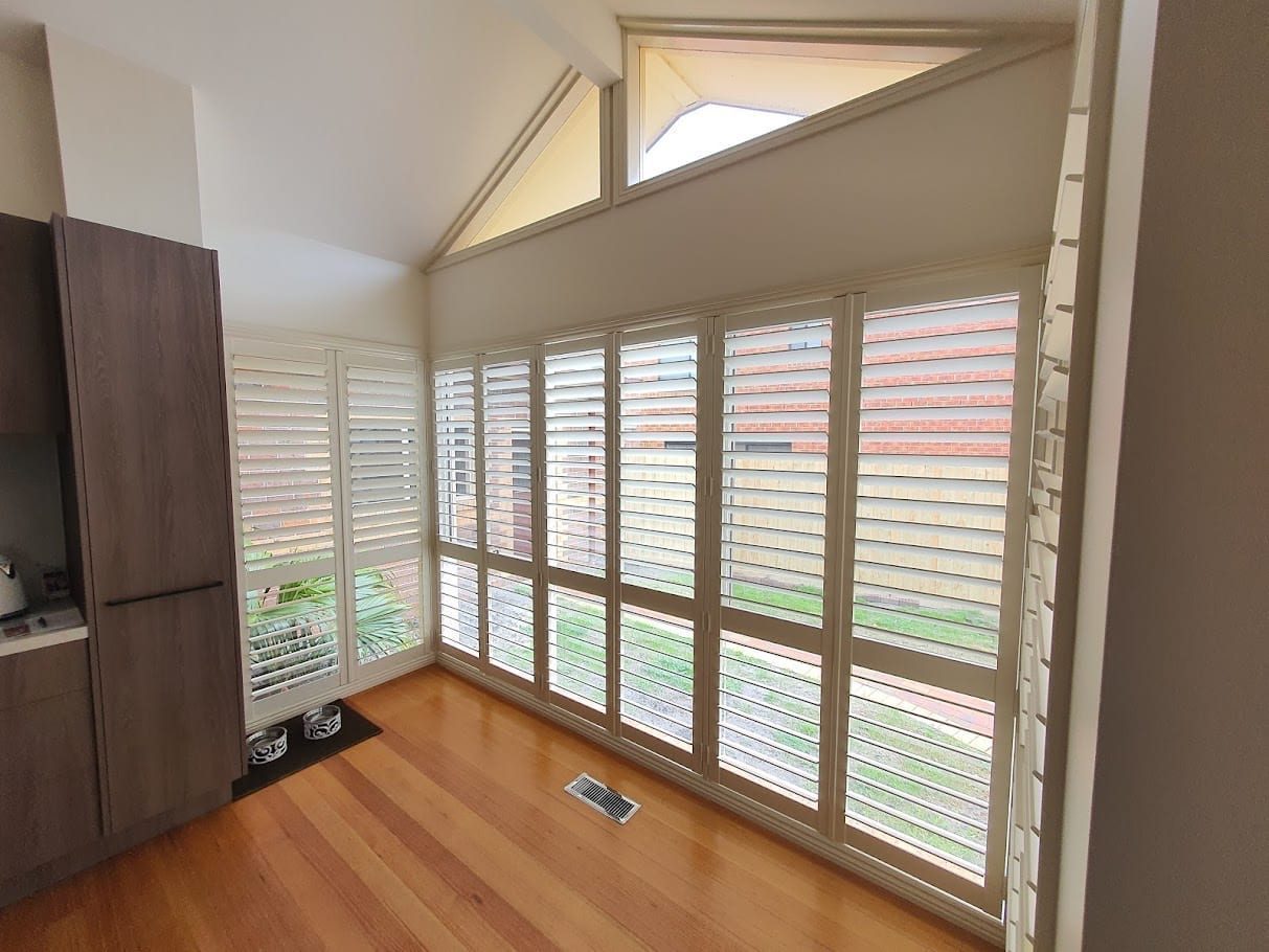 Plantation shutters on floor-to-ceiling windows in a Melbourne home