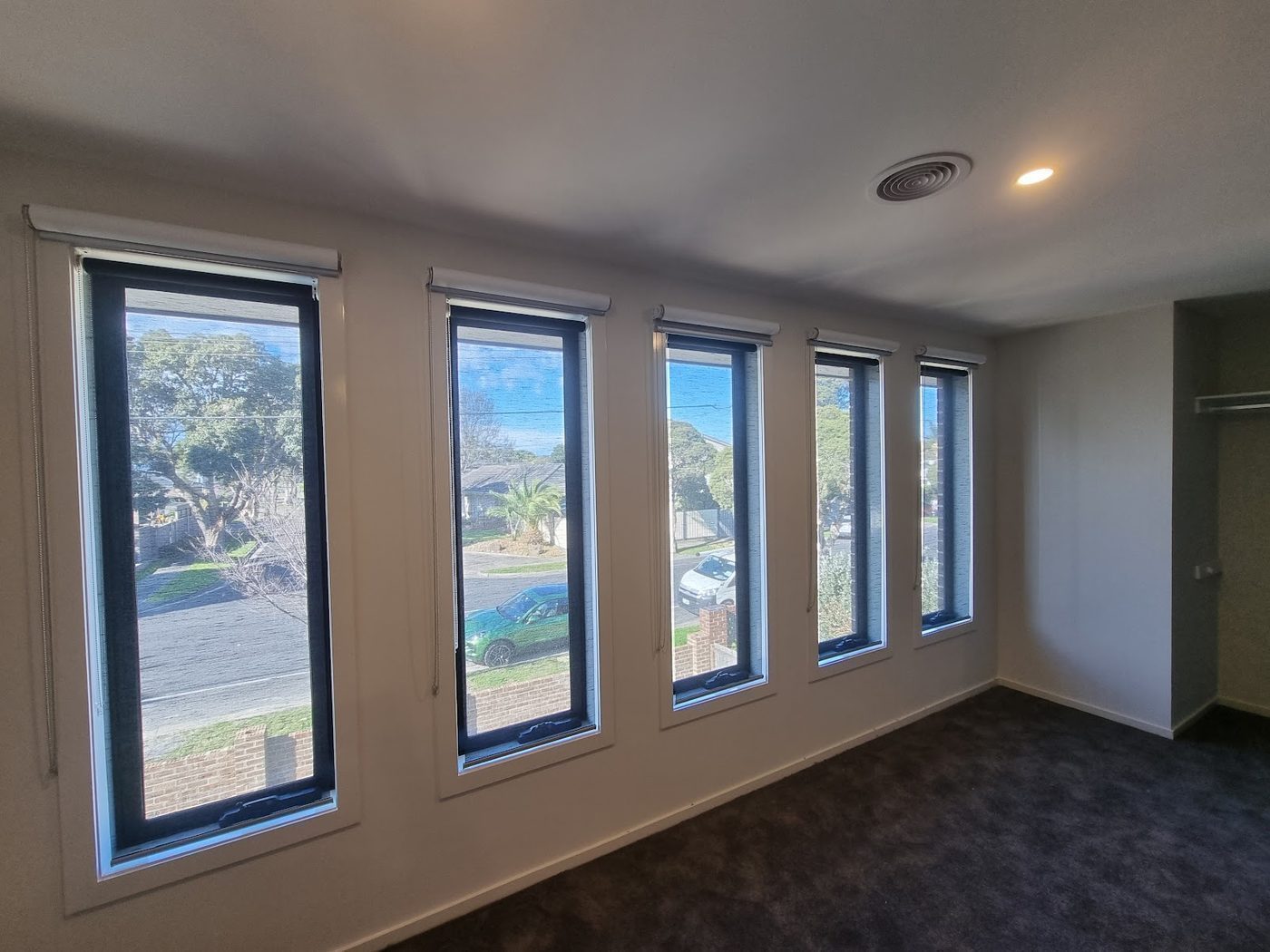 Sunscreen roller blinds custom made for a living area — Melbourne property