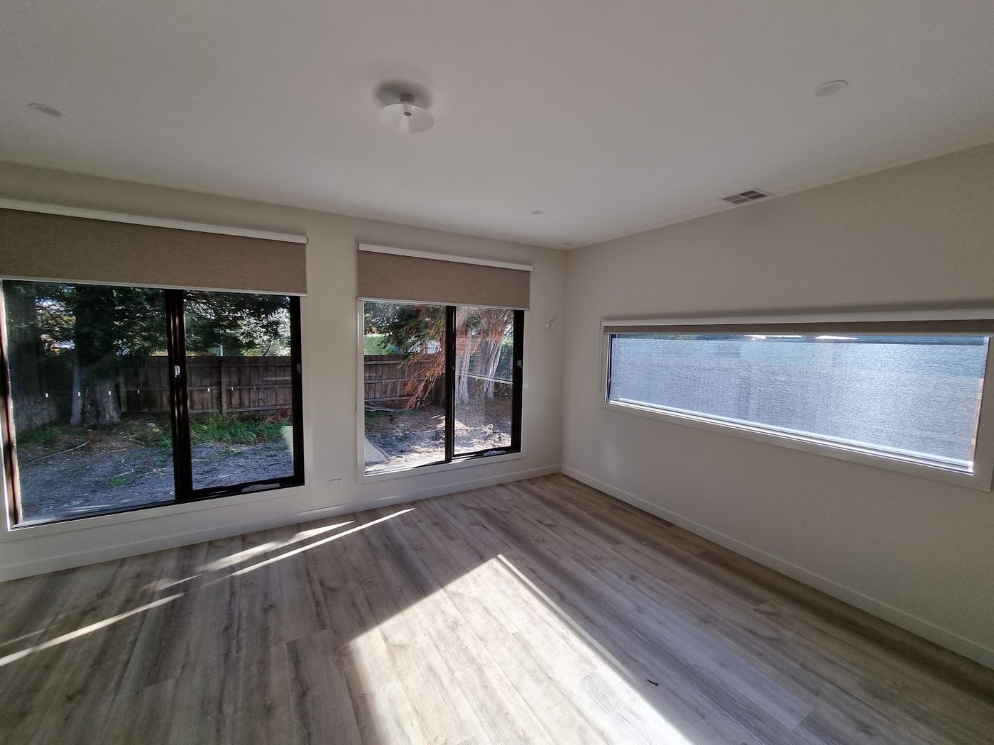 Light-filter roller blinds in a main living room — Melbourne residence