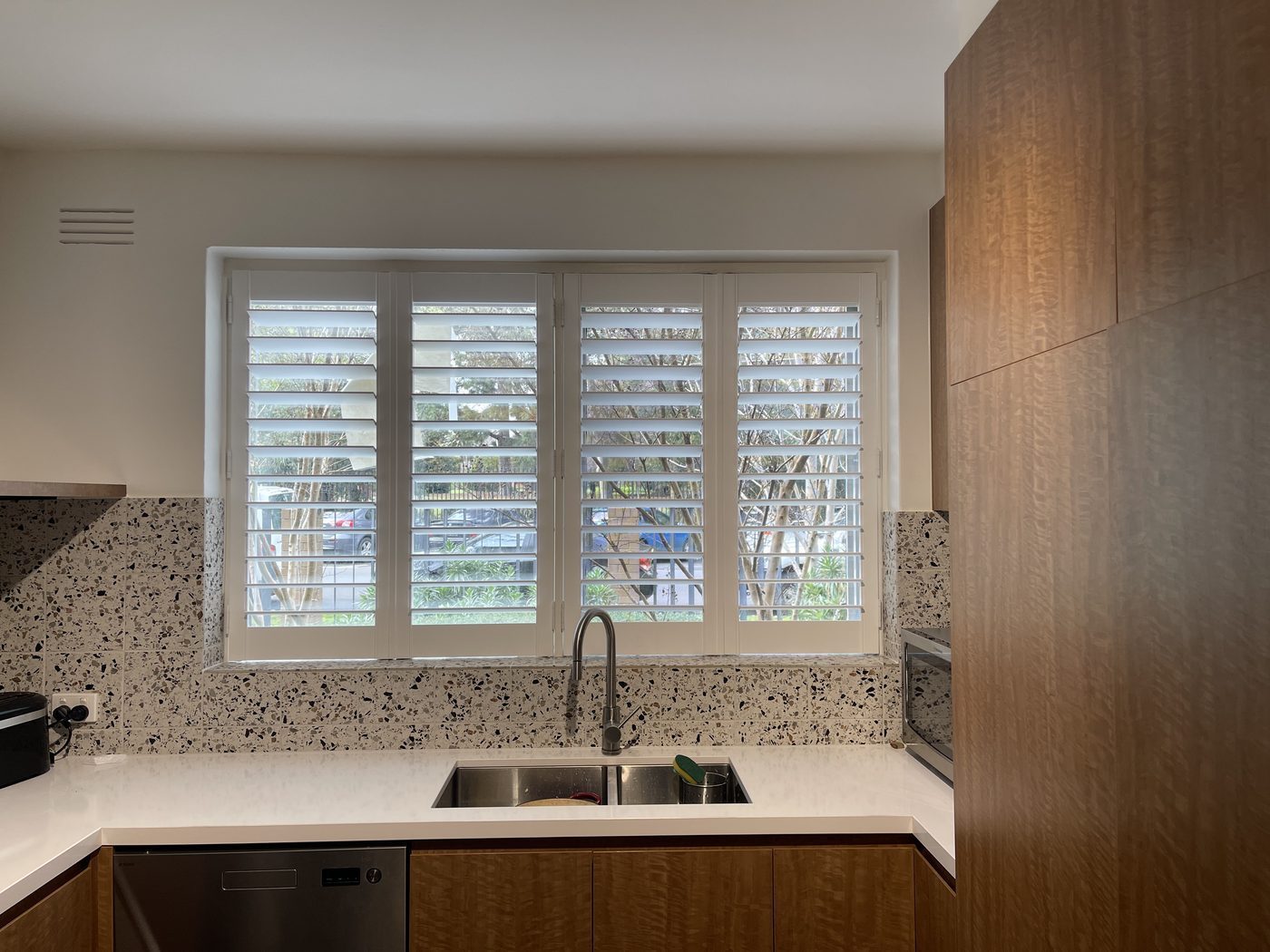 Custom plantation shutters installed in a kitchen area — Melbourne residence