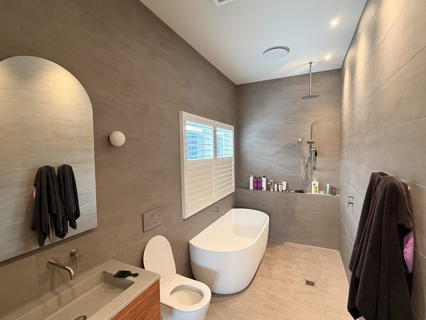 Timber-look plantation shutters custom made for a ensuite — Melbourne house