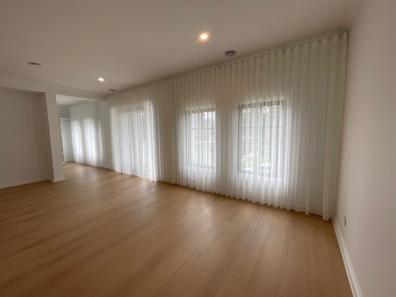 Sheer linen curtains and roller blinds in a bedroom — Melbourne apartment