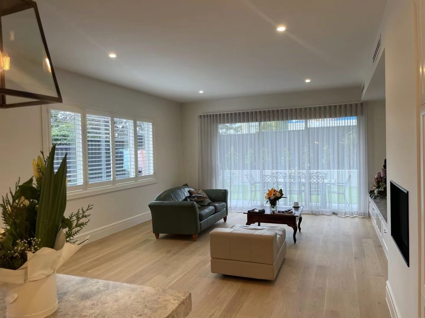 Plantation shutters and curtains in a living room — Melbourne townhouse