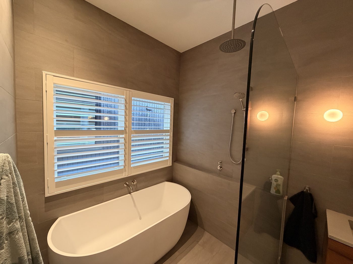 Plantation shutters with adjustable louvres fitted in a bathroom — Melbourne residence