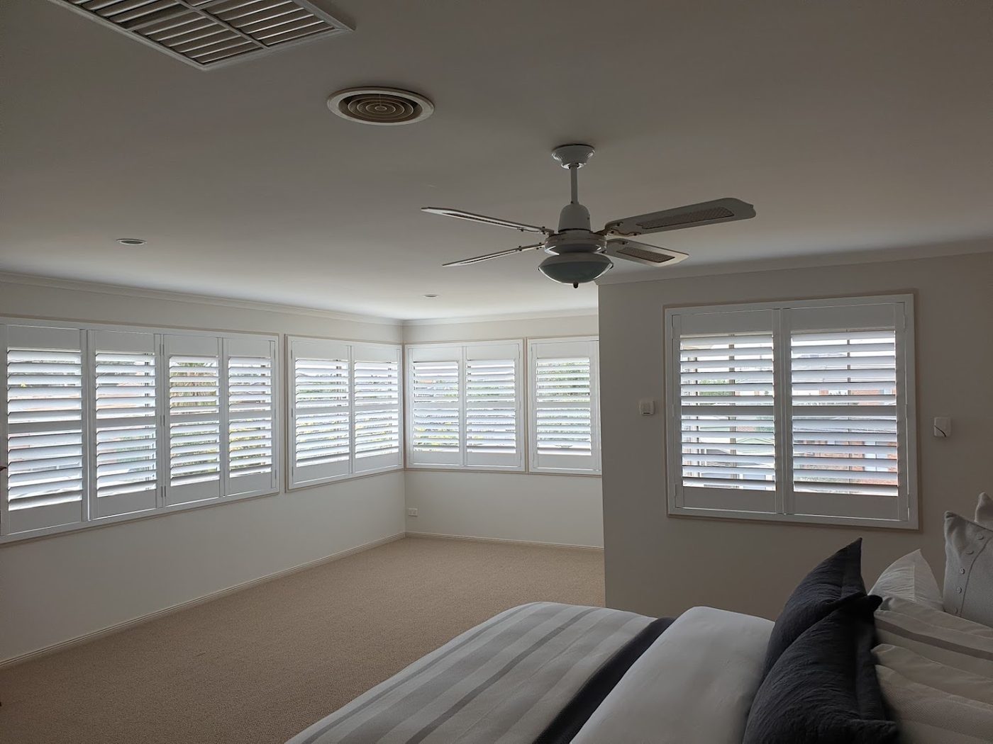 Custom plantation shutters installed in a master bedroom — Melbourne apartment