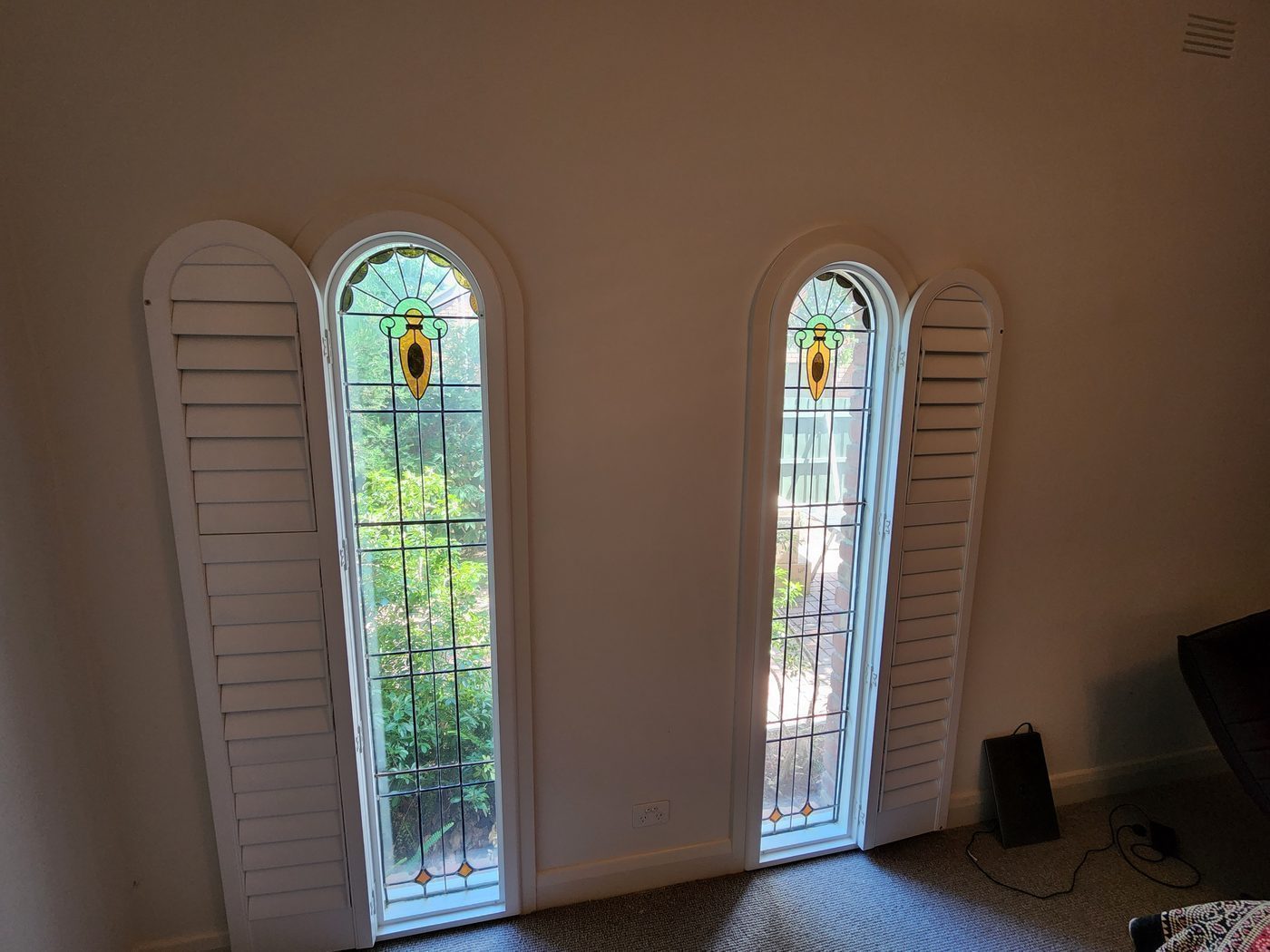 White plantation shutters fitted in a main bedroom — Melbourne apartment