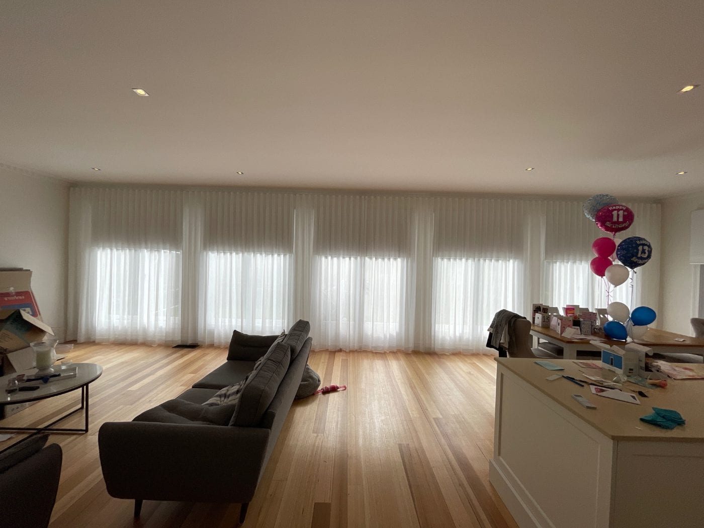 Custom curtains over roller blinds in a Melbourne living room