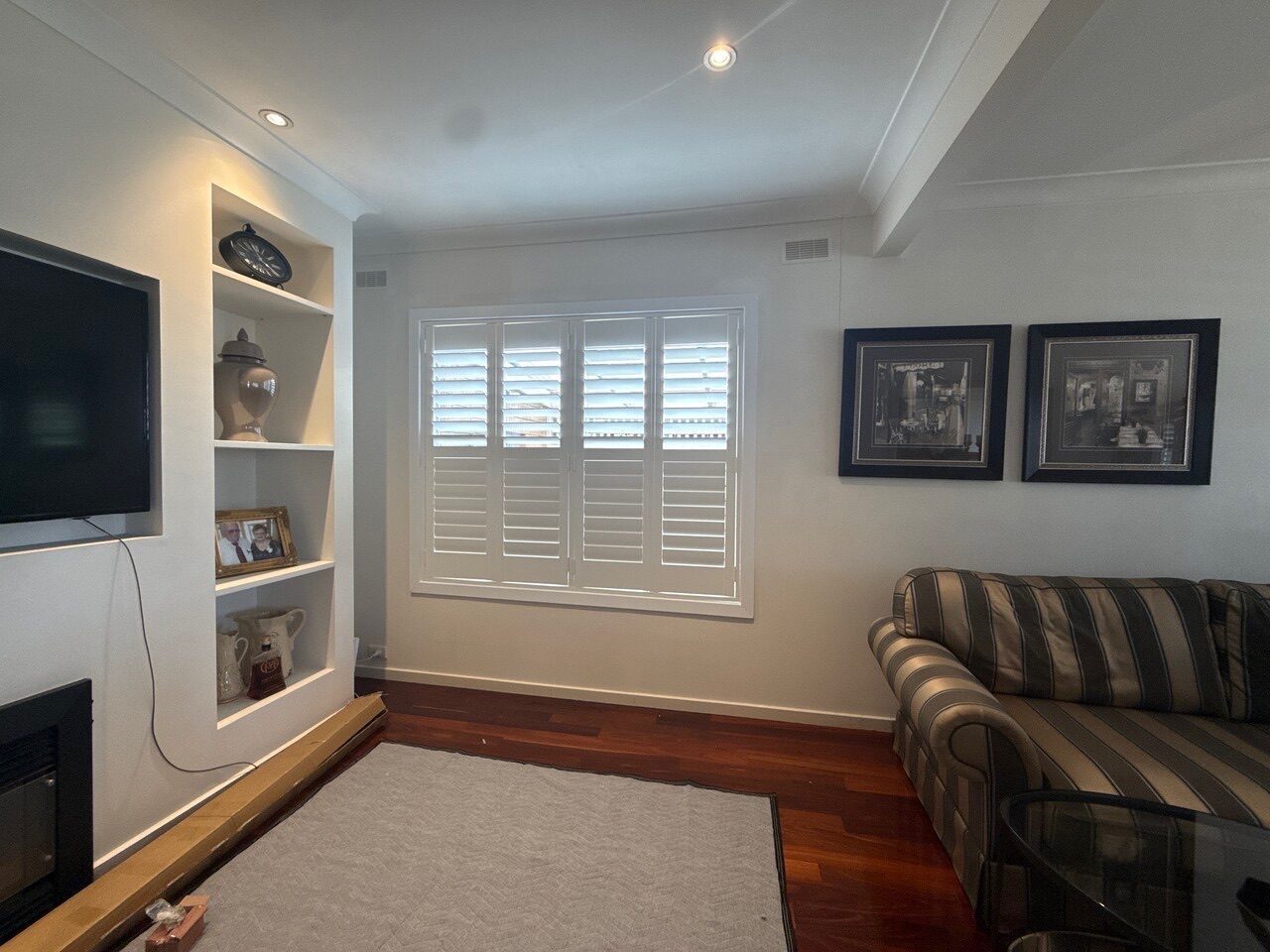 Plantation shutters with wide louvres in a open-plan living area — Melbourne home