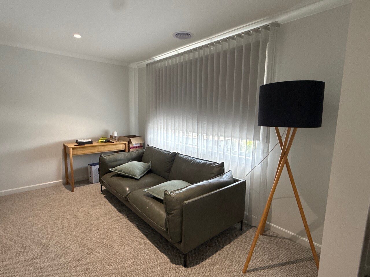 Layered window treatments — curtains and roller blinds — in a Melbourne lounge