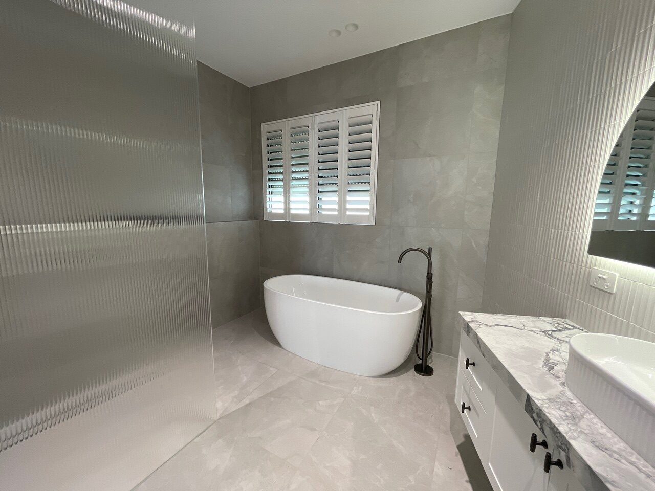 Plantation shutters with wide louvres custom made for a bathroom — Melbourne house