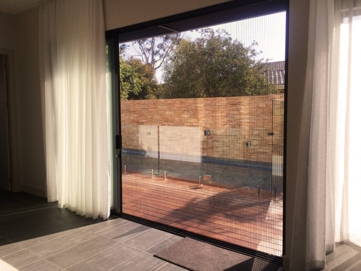 Pleated fly screens installed in a lounge room — modern Melbourne home