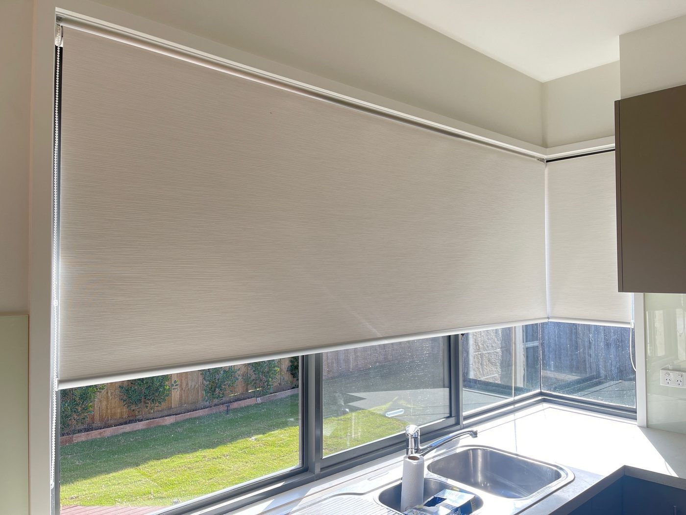 Custom roller blinds installed in a kitchen area — Melbourne house