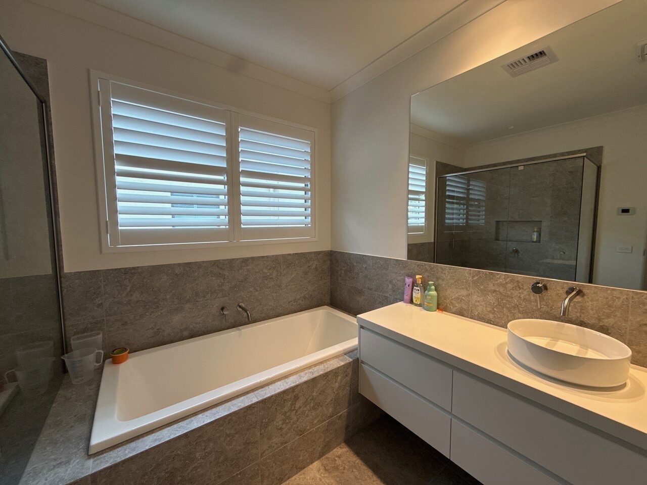 Bi-fold plantation shutters installed in a bathroom and ensuite — Melbourne property