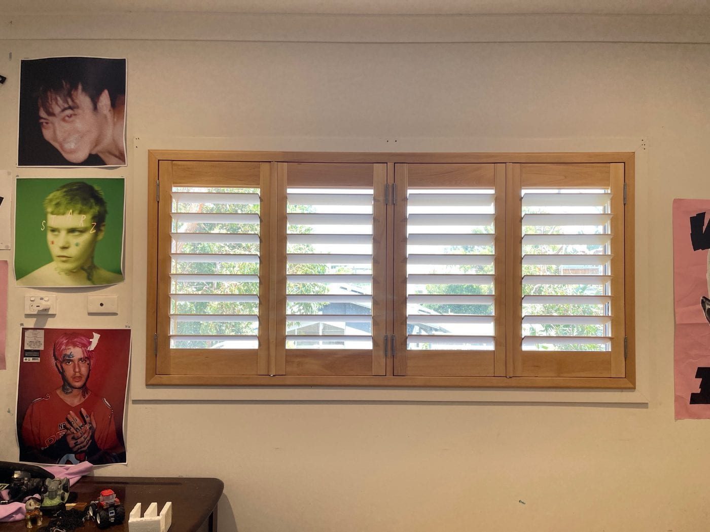 Plantation shutters with bi-fold configuration in a Melbourne bedroom