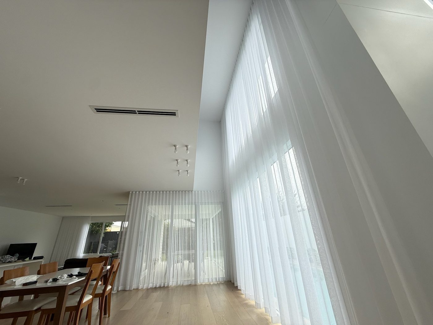 Sheer curtains fitted in a open-plan living area — modern Melbourne home