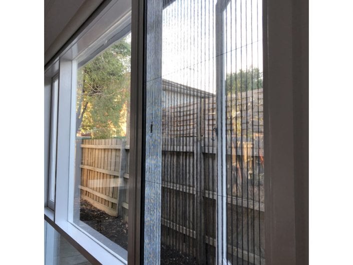 Retractable fly screens in a living room — Melbourne residence