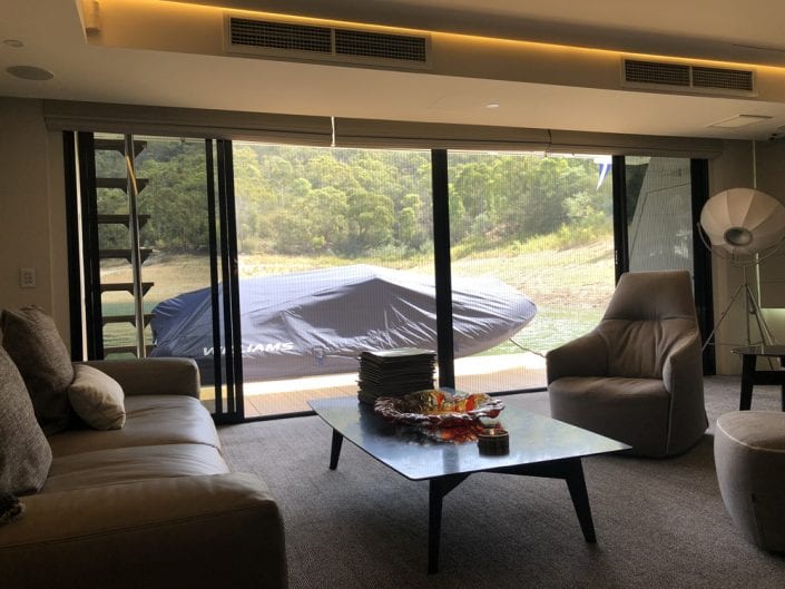 Pleated fly screens installed in a lounge room — Melbourne house