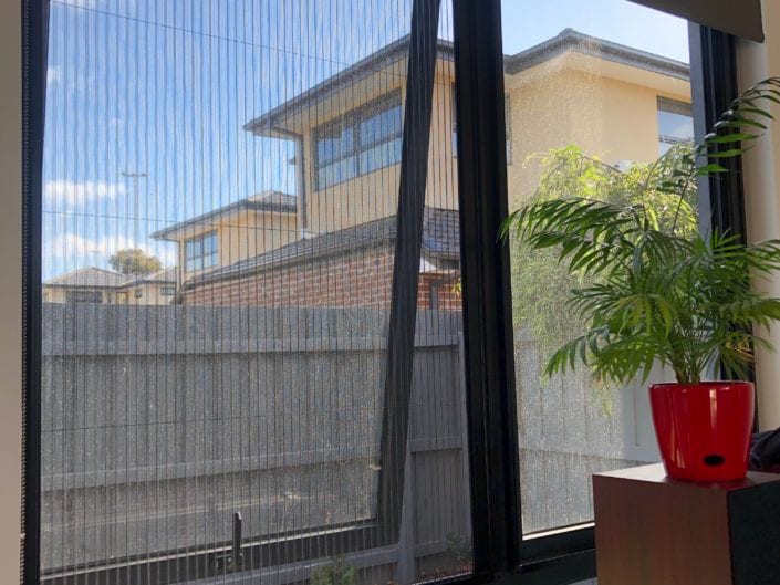 Retractable fly screens in a dining room — Melbourne apartment