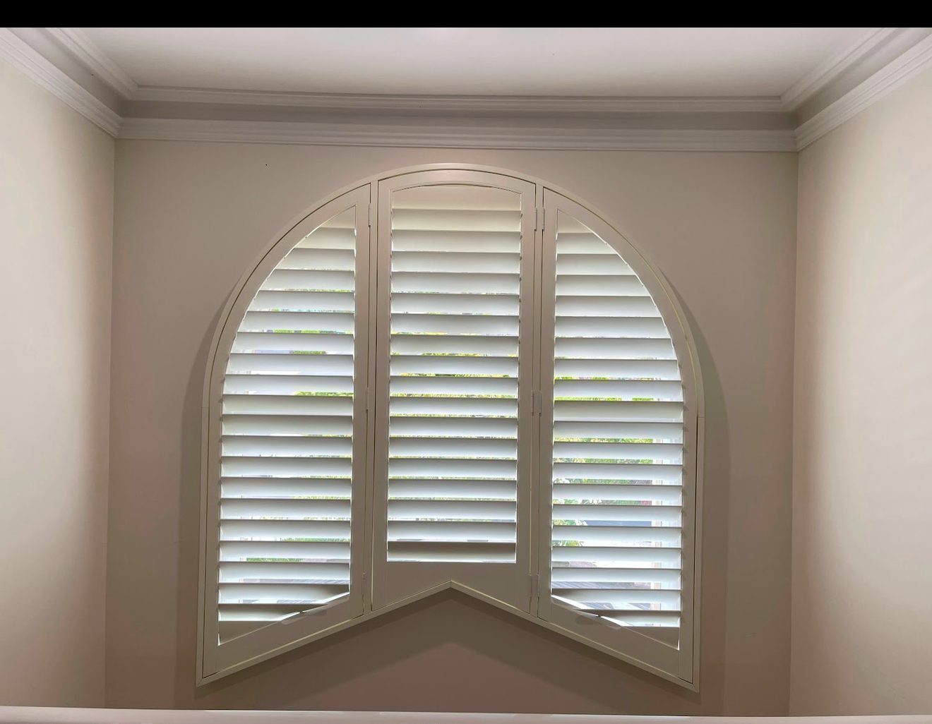 Plantation shutters with adjustable louvres fitted in a lounge room — Melbourne residence