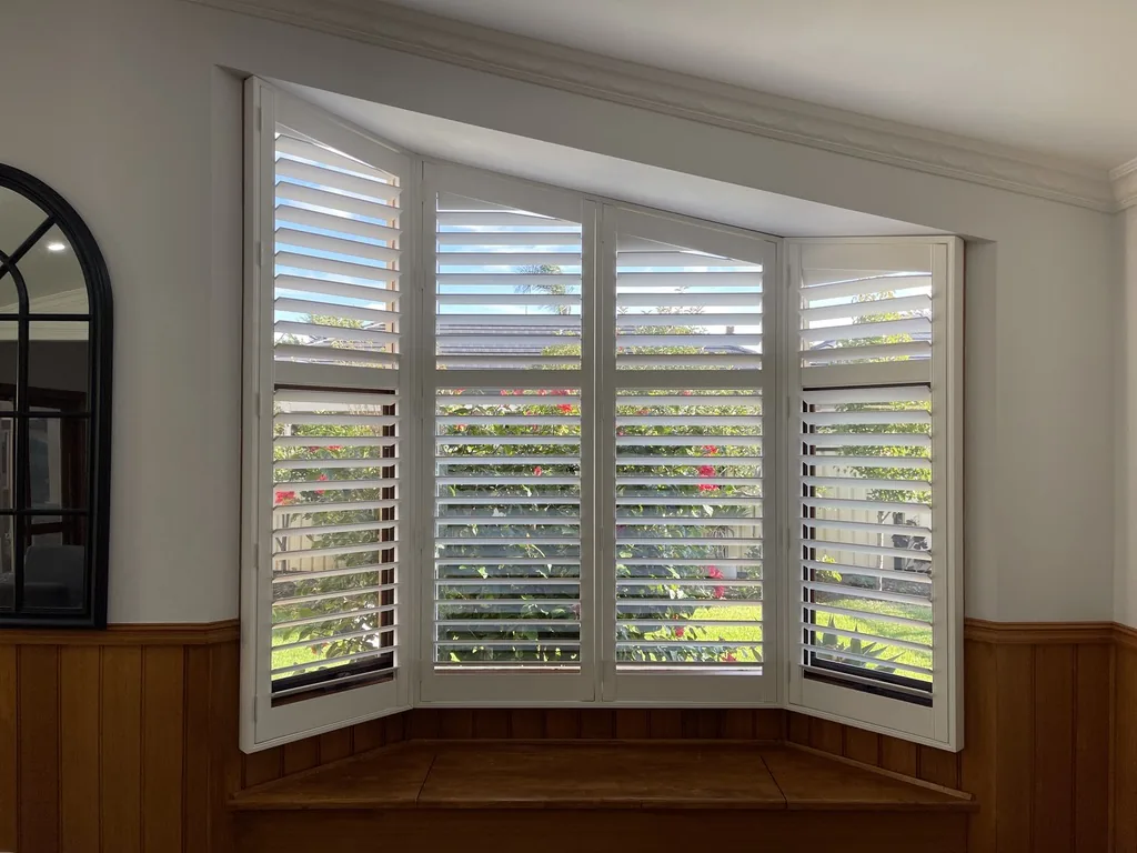 Plantation shutters installed on a bay window in a Melbourne home — We Inspire Blinds